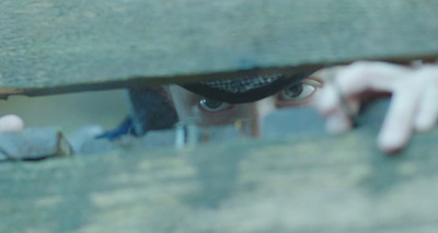 a close up of a person peeking out from behind a wall