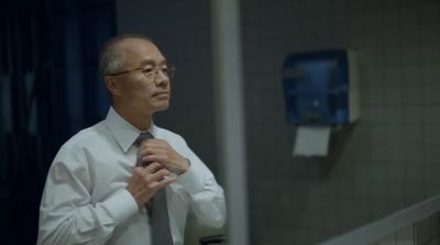 a man in a white shirt and tie standing in front of a mirror