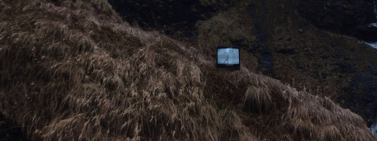 a car parked on the side of a hill next to a waterfall