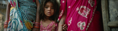 a little girl is peeking out from behind a curtain