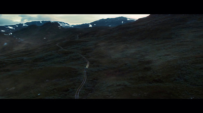 an aerial view of a winding road in the mountains