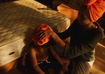 a woman putting a towel on a child's head