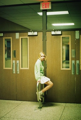 a woman leaning on a pole in front of a door