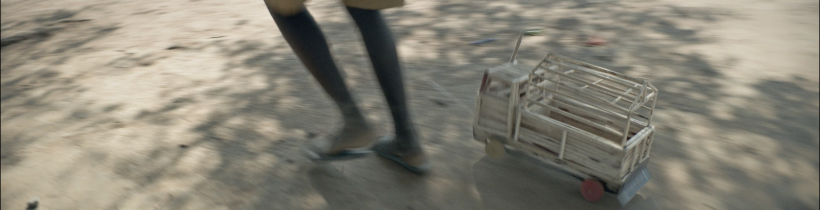 a person walking with a cart on a dirt road