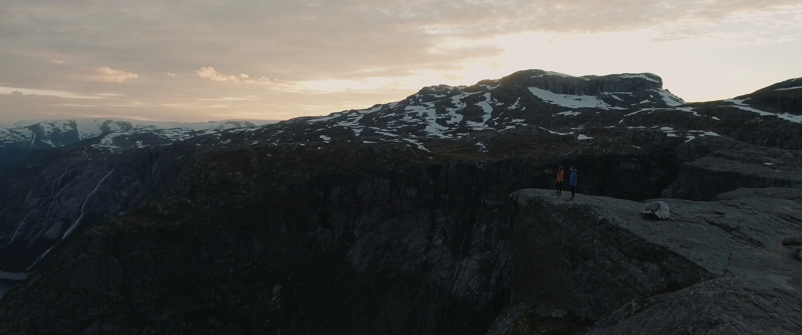 a person standing on top of a cliff overlooking a mountain