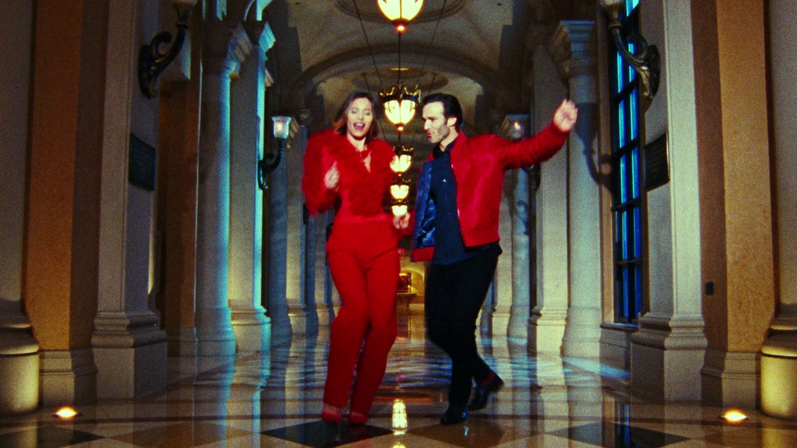 two men in red suits standing in a hallway