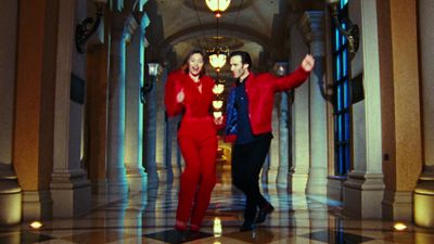 two men in red suits standing in a hallway