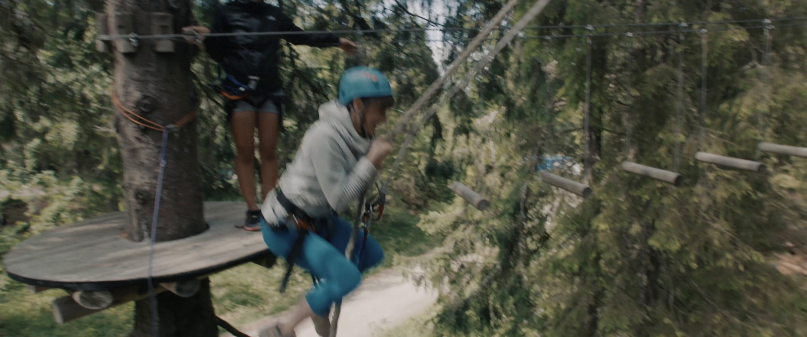 a group of people on a zip line in the woods