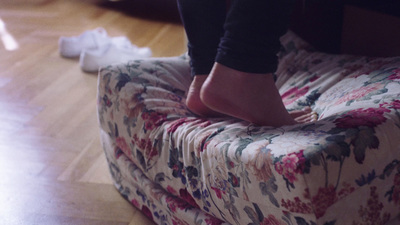 a person standing on top of a flowered couch