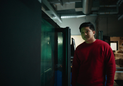 a man in a red shirt standing next to a refrigerator