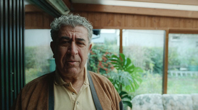 a man standing in a living room next to a window