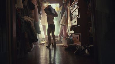 a person standing in a room with a bunch of clothes