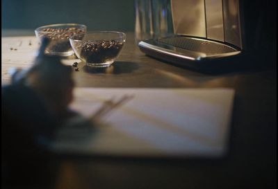 a person writing on a piece of paper next to a coffee maker