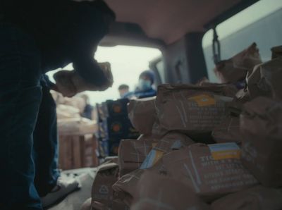 a group of people standing around a pile of bags