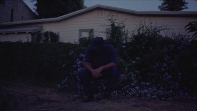 a person sitting on a chair in front of a house