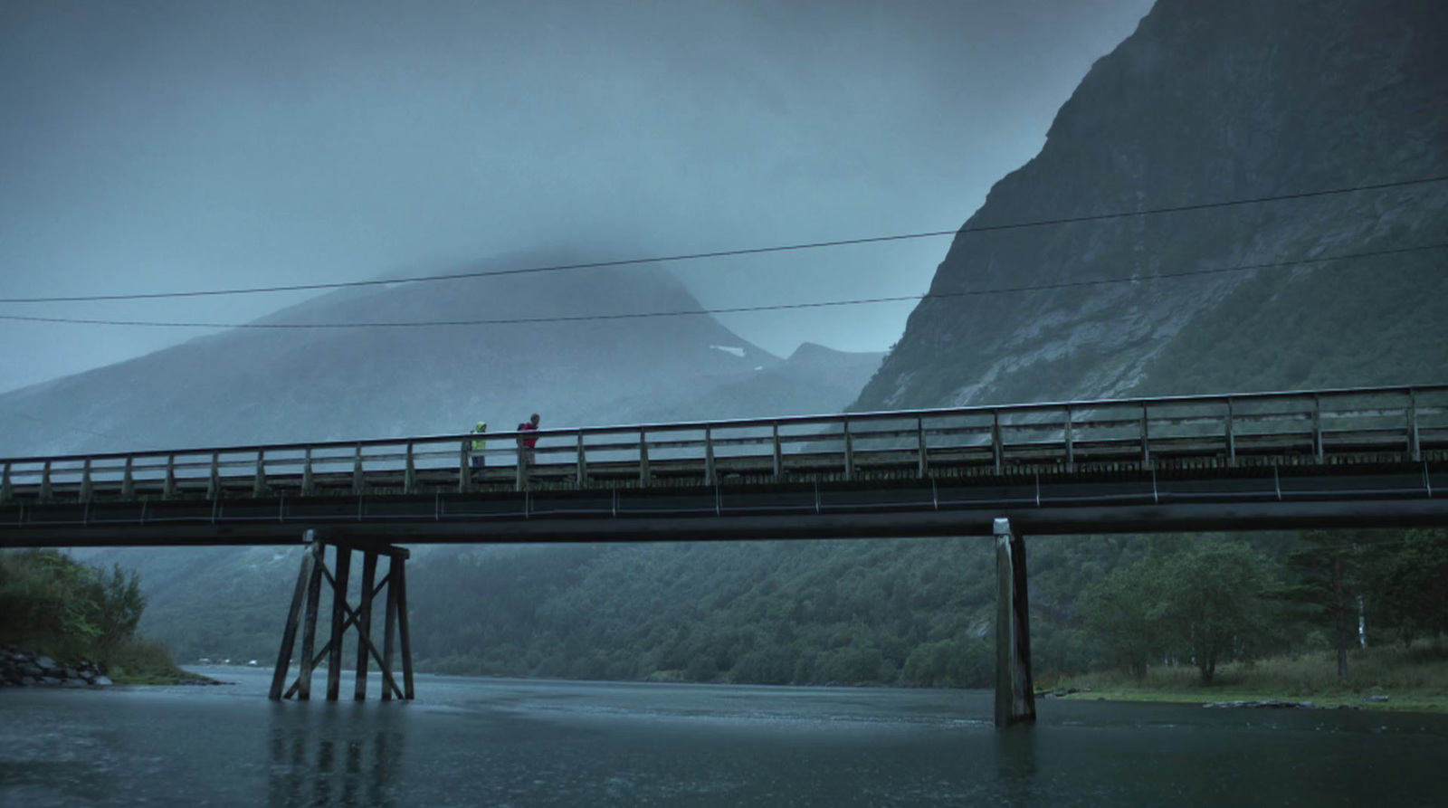 a person standing on a bridge over a river