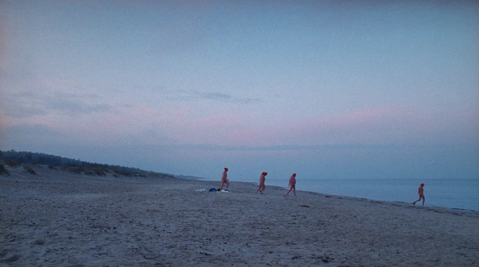 a group of people standing on top of a sandy beach