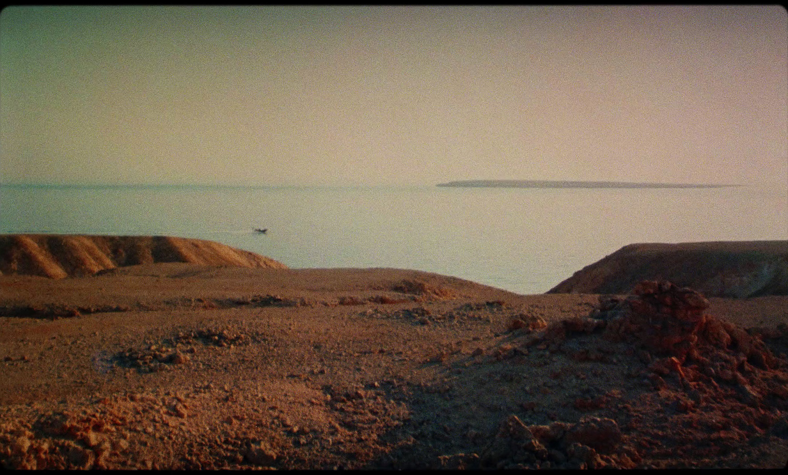 a large body of water sitting next to a sandy beach