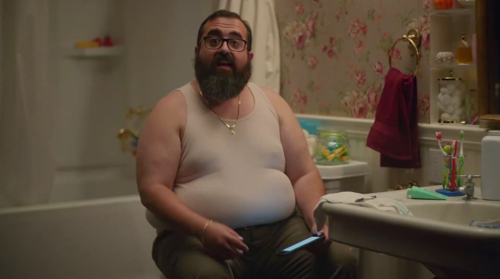 a man with a large belly sitting in a bathroom