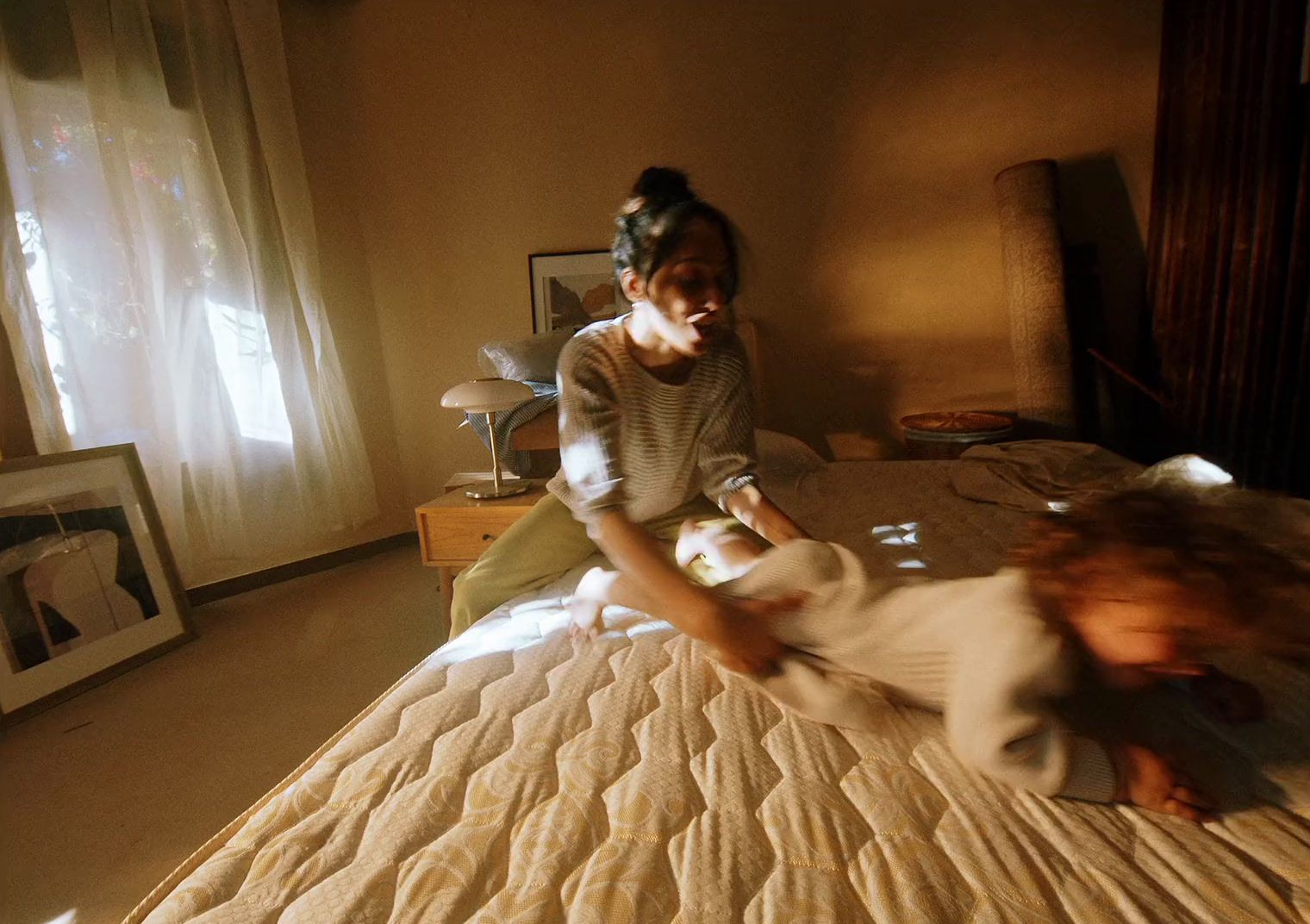 a woman sitting on top of a bed next to a child