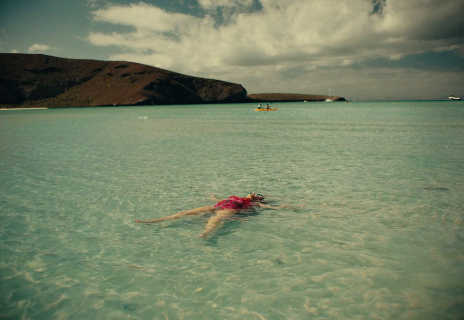 a person floating in the ocean on a clear day