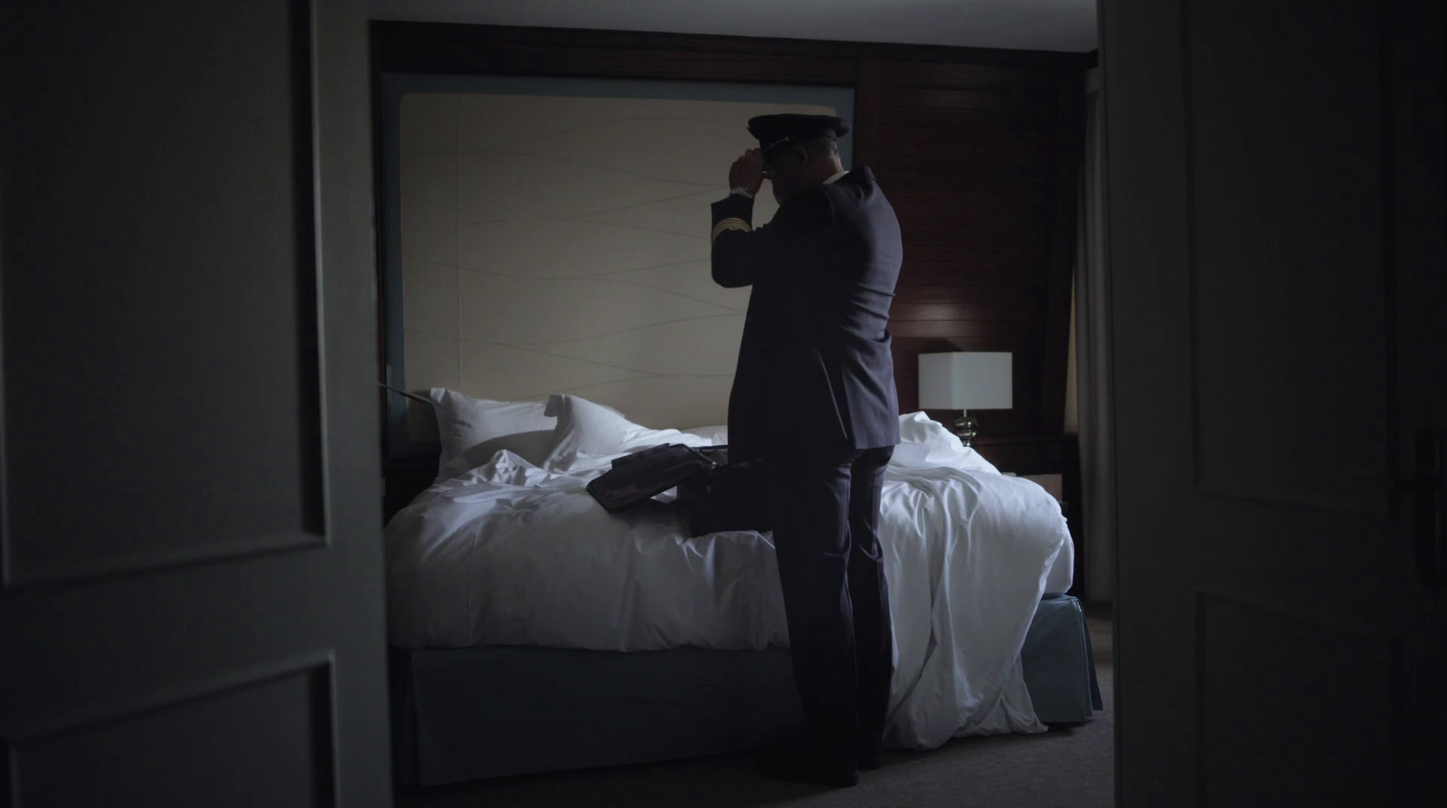 a man standing in front of a mirror in a bedroom