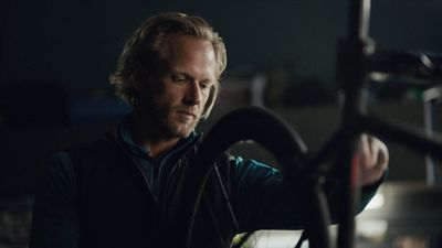 a man holding a steering wheel in a dark room