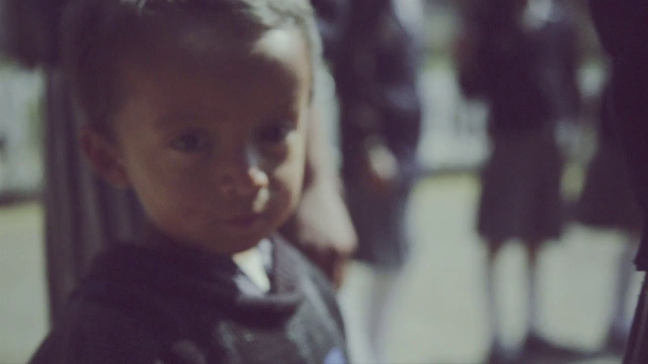 a little boy standing in front of a group of people