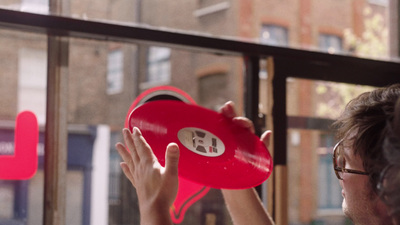 a person holding a red object in front of a window