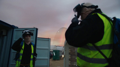 a man in a safety vest standing next to a container