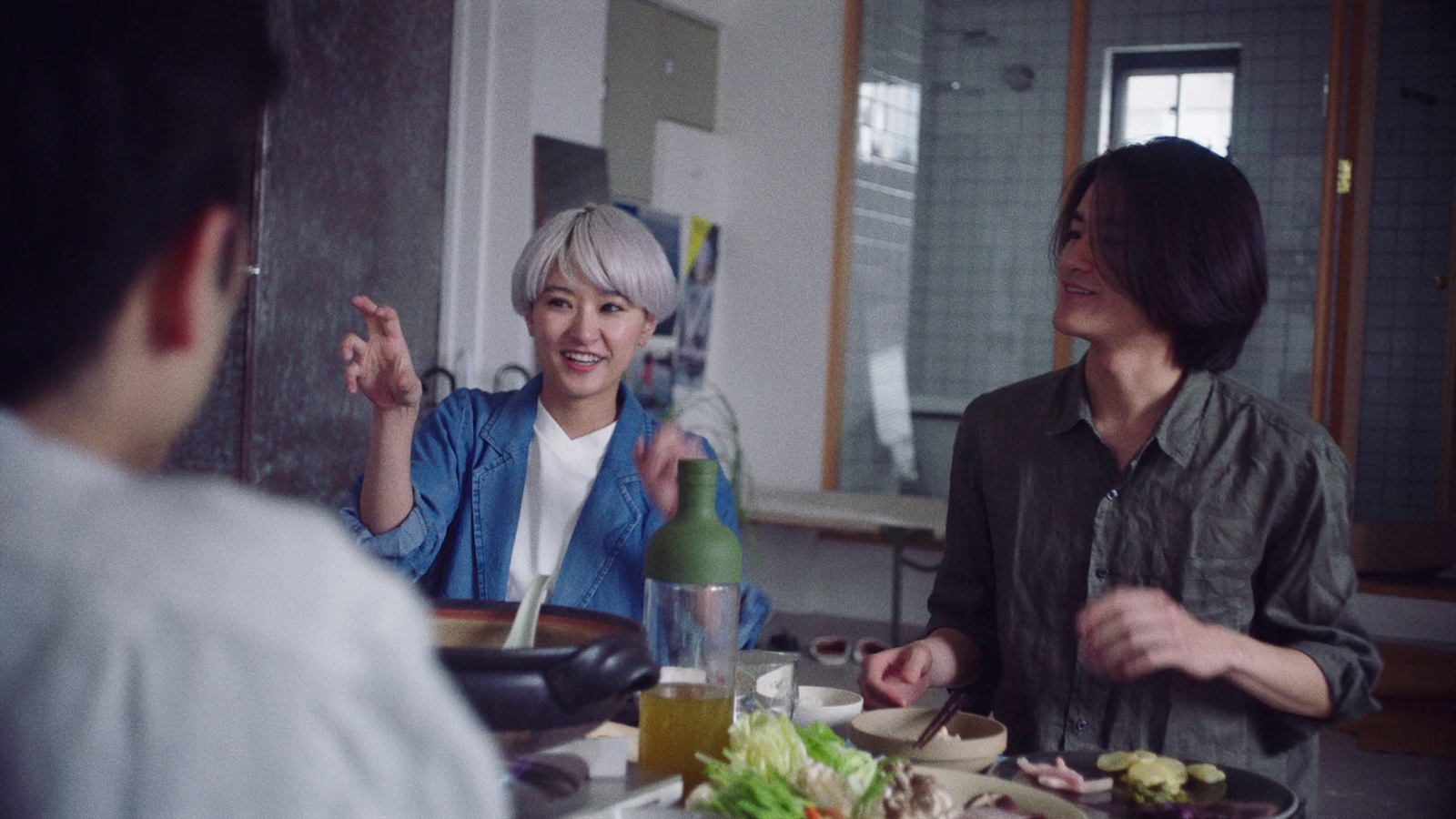 a group of people sitting around a table with food