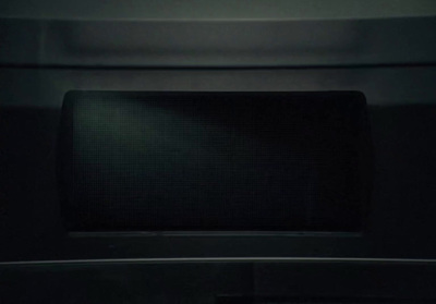 a microwave oven with a light on in a dark room