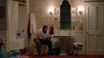 a man sitting on a chair in a bathroom