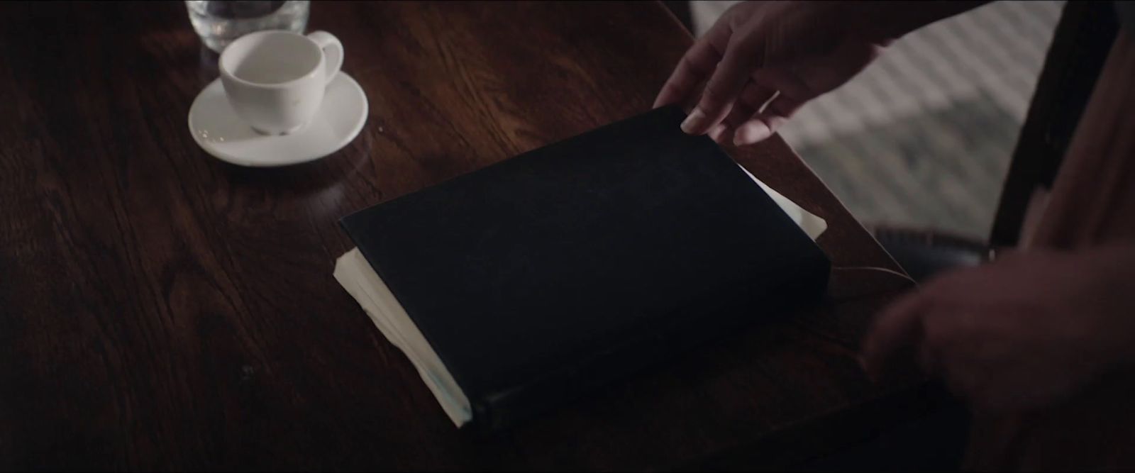 a person is holding a book on a table