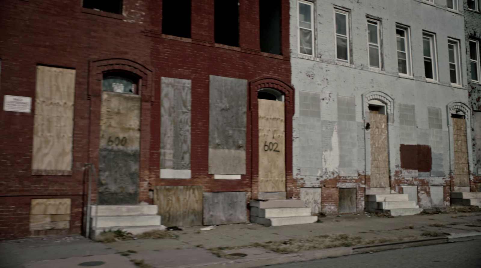 a row of boarded up buildings on a city street