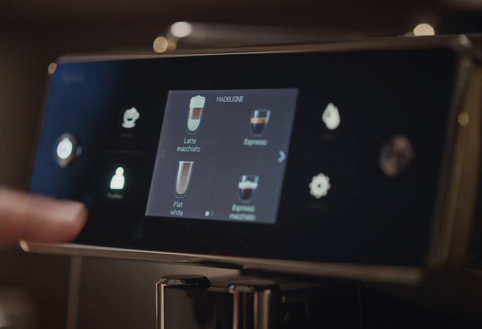 a person is pressing buttons on a coffee machine