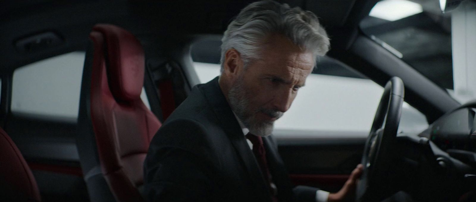 a man in a suit and tie sitting in a car