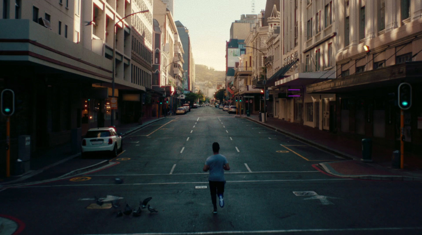 a man riding a skateboard down a street next to tall buildings