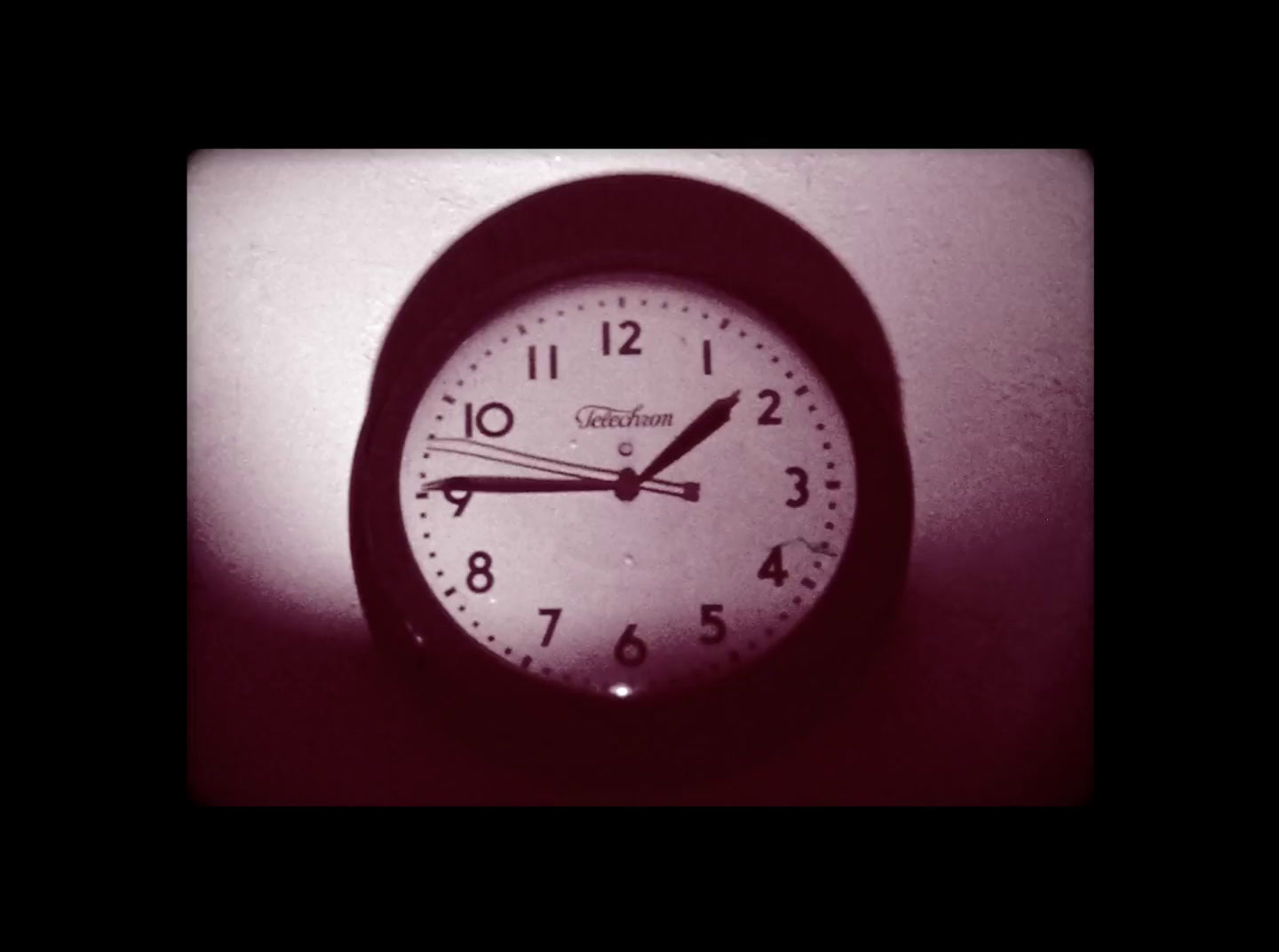 a black and white photo of a clock on a wall