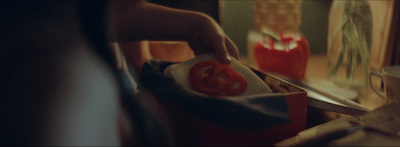 a person cutting a tomato in a bag