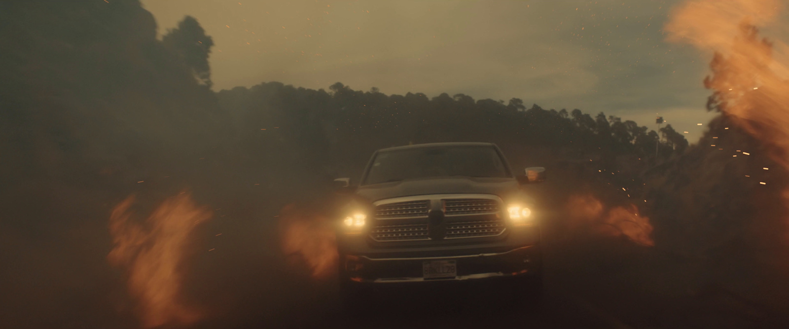 a white truck driving down a road next to a forest