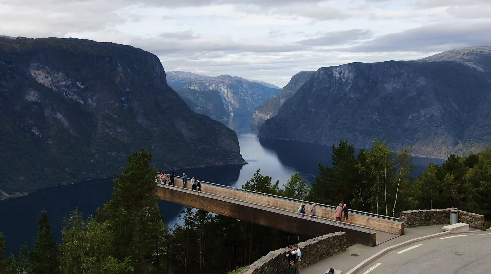 a bridge over a lake with people walking on it