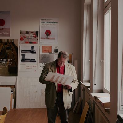 a man standing in a room holding a piece of paper