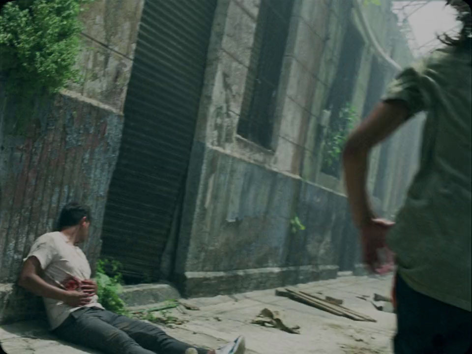 a man sitting on the ground next to a building