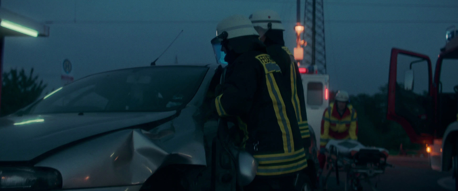 a fireman standing next to a car on a street