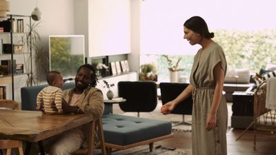 a woman standing in a living room next to a table