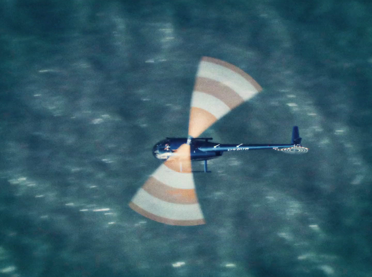 an aerial view of a helicopter flying over the ocean