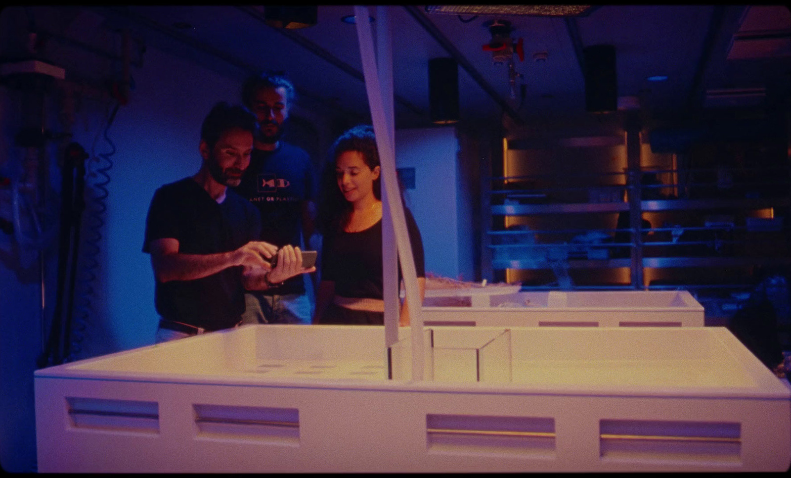 a group of people standing around a model of a building