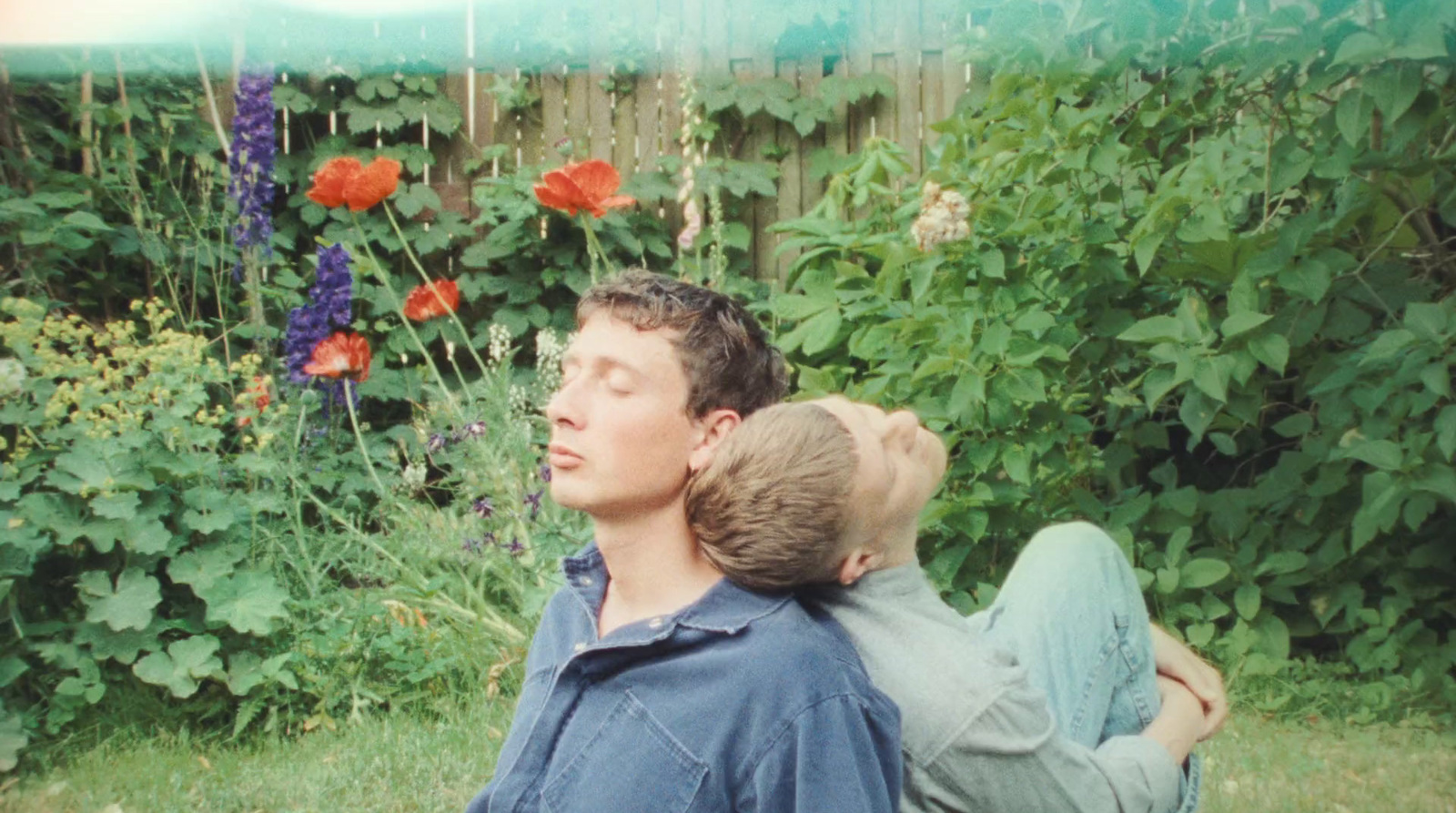 a man and a boy are sitting in the grass