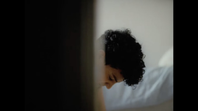 a man with curly hair looking at his cell phone